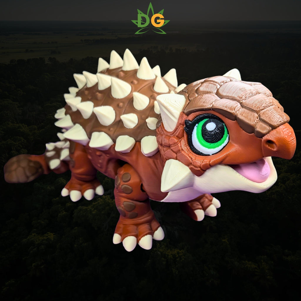 A small, brown, 3D-printed flexi ankylosaurus with large green eyes and cream-colored spikes.